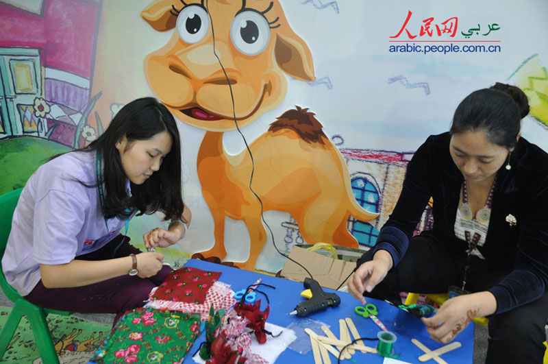 سوسن، طالبة صينية تدرس  اللغة العربية تقدم خدمات تطوعية فى  معرض بكين الدولي للكتاب (2)