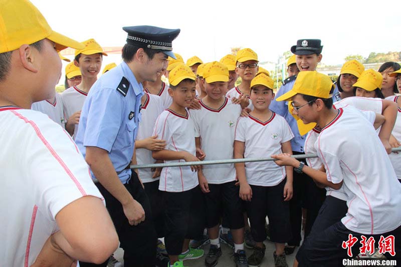 رجل الشرطة يوجه الطلاب الجدد  في مكافحة المجرمين قبيل افتتاح الفترة الدراسية الجديدة في مدينة تايتشو بمقاطعة تشجيانغ في يوم 26 أغسطس. 