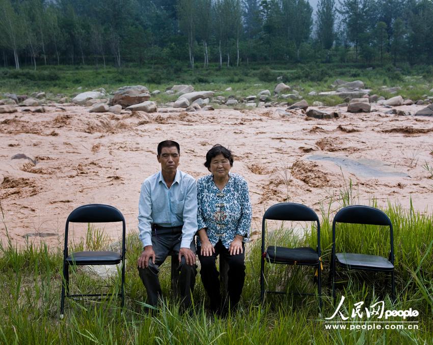 تيان دونغ لين البالغ من العمر 64 عاما وزوجته في ضفة نهر لوهخه القريبة من بيتهما. يعمل أولادهما الثلاثة في المدينة.  