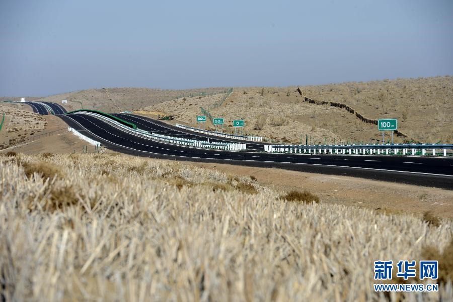 يظهر في الصورة الملتقطة يوم 21 أكتوبر الحالي جزء من الطريق السريع الصحراوي "وودا"،  قد تم تثبيت الرمال المتحركة علي جانبي الطريق بشبكة العشب.