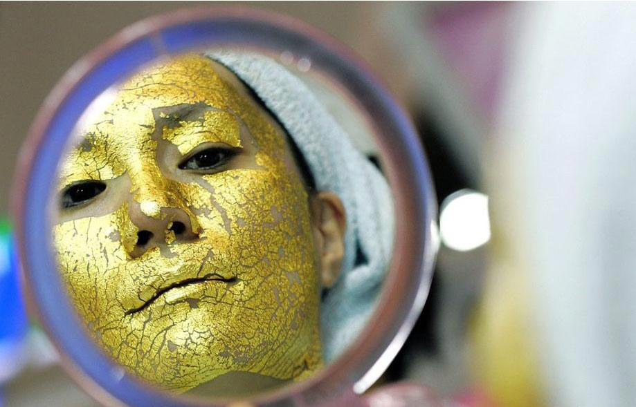  امرأة تجرب قناع الوجه الذهبي في معرض تجاري لمنتجات التجميل في طوكيو اليابانية يوم 8 مايو عام 2007.