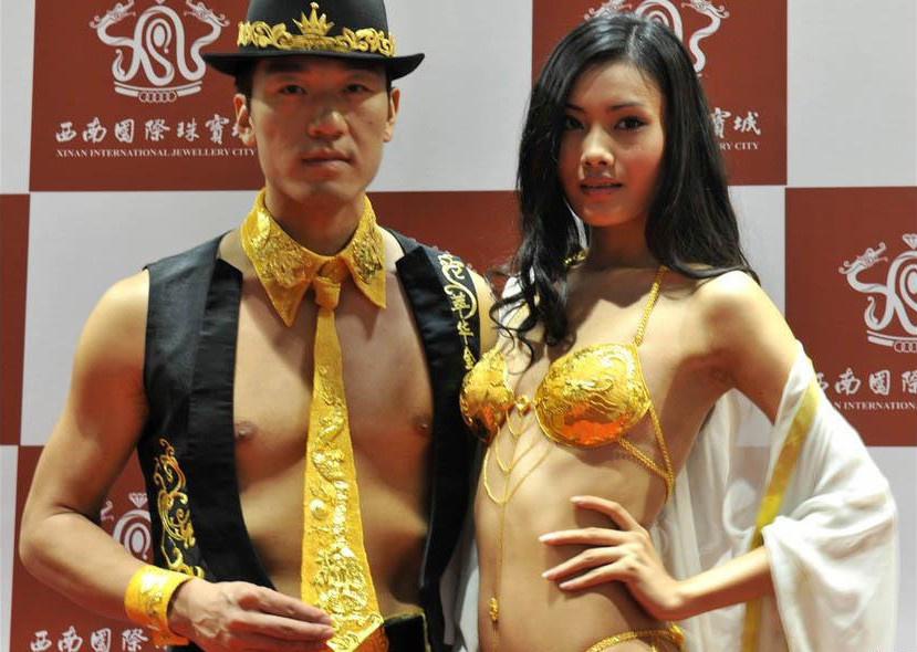 عرض عارض وعارضة الأزياء الملابس الداخلية وربطة العنق وربطة المعصم الذهبية فى معرض مقام فى مدينة تشونغتشينغ جنوب غربي الصين يوم 26 يونيو عام 2009.