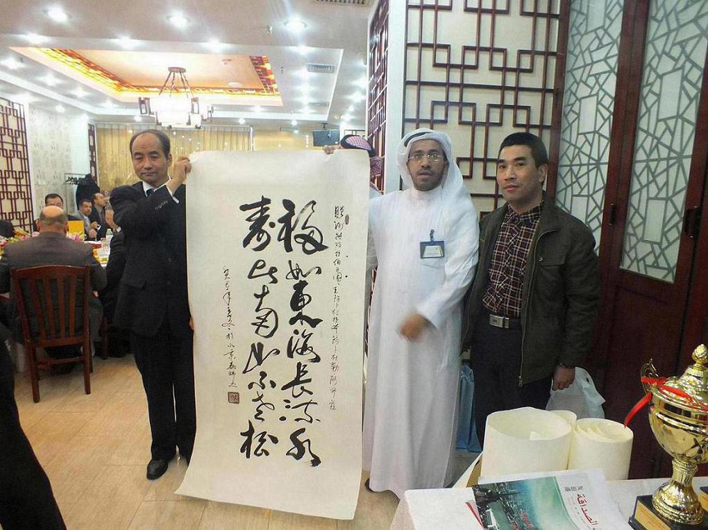 خطاط صيني يكتب عبارة تهنئة بعيد ميلاد العاهل السعودي 