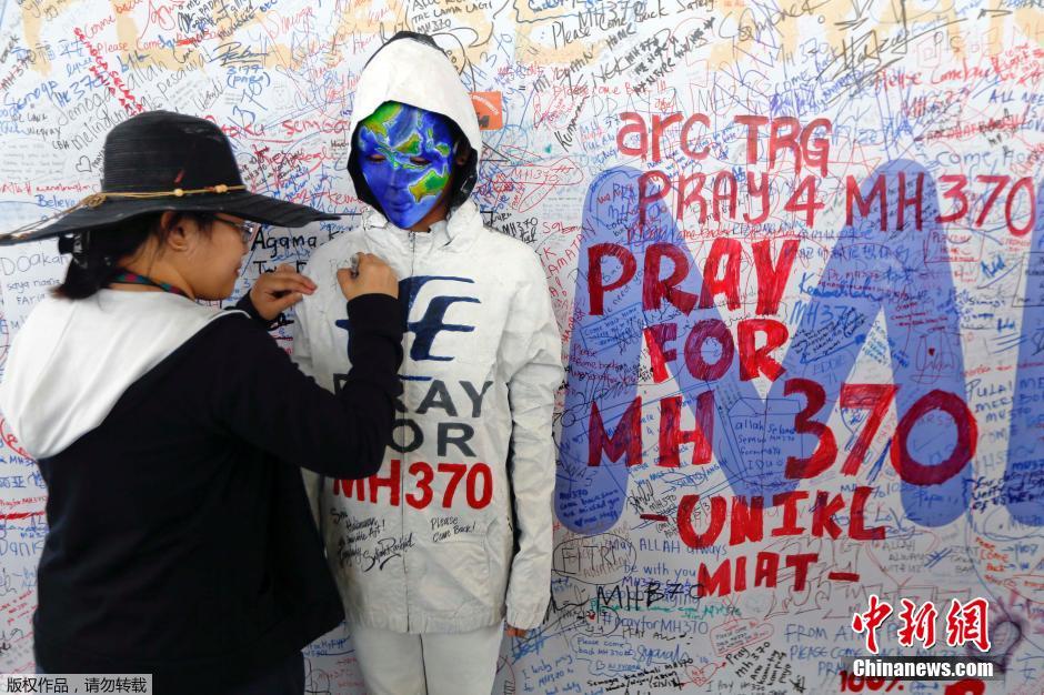 فنان يرسم خريطة على وجه عارضة للصلاة  والدعاء من اجل ركاب الطائرة الماليزية المفقودة  (2)